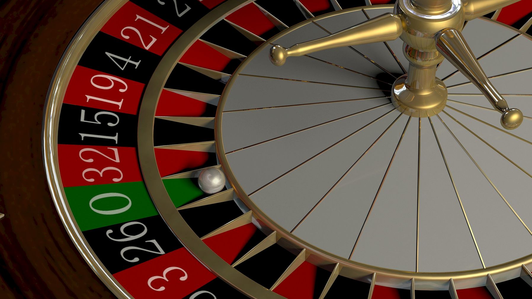 A roulette wheel with a ball resting between the numbers 0 and 32 is depicted in this image, showing sections of red, black, and green slots.